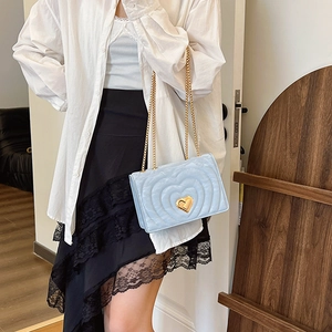 Elegant light blue quilted chain bag with a gold heart clasp and crossbody chain strap