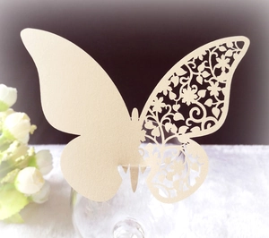 Detail of laser-cut butterfly cup card in champagne pearlescent paper for wedding decor