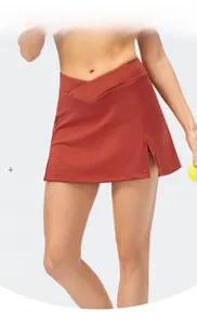 Detail of high-waist brick red tennis skirt with side slit and breathable stretch fabric