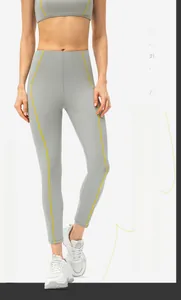 Détail du legging de yoga taille haute avec coutures contrastées jaunes et tissu élastique