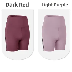 Dettaglio dei pantaloncini da yoga a vita alta in rosso scuro e viola con bordi laterali