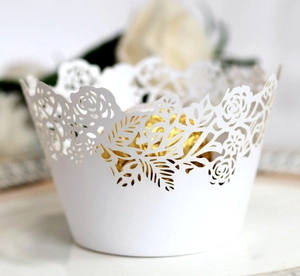 Close-up of laser-cut white rose floral cupcake wrapper with gold chocolate interior