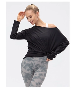 Λεπτομέρεια μαύρου yoga top με έξω ώμους, κόμπο στο στρίφωμα και tie-dye κολάν