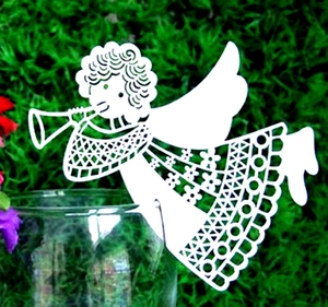 Detailed laser-cut white angel place card with intricate floral patterns on green moss