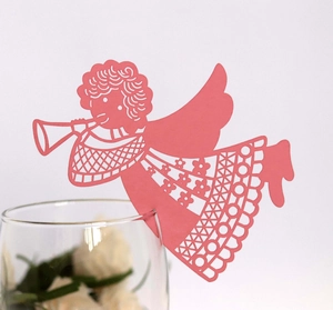 Detail of pink laser-cut angel place card with intricate wing patterns on wine glass