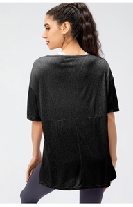Back view of a loose fit black sports t-shirt with side slits for women running and yoga