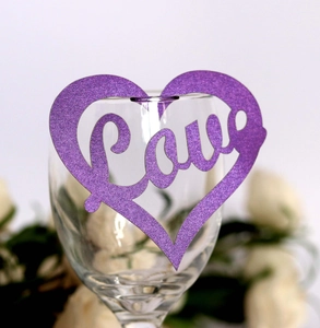 Purple glitter heart place card with Love cutout on a glass for wedding party