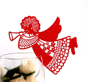 Detail of red laser-cut angel wine glass card with intricate hollow patterns on glass