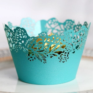 Detailed laser-cut rose pattern on mint green cupcake wrapper with elegant finish