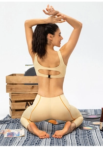 Détail du dos de l'ensemble de yoga beige avec coutures orange sur le legging taille haute