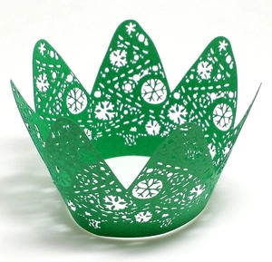 Detail of green laser-cut paper cupcake wrappers featuring snowflake patterns for Christmas