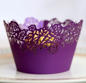 Detailed laser cut rose pattern on deep purple cupcake wrapper with gold chocolate