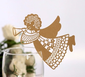 Macro detail of gold glitter laser-cut angel place card fixed on wine glass rim