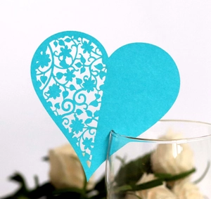 Sky blue heart-shaped laser cut place card with floral details on a glass rim