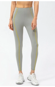 Gros plan sur un legging de yoga gris taille haute avec des coutures contrastées jaunes