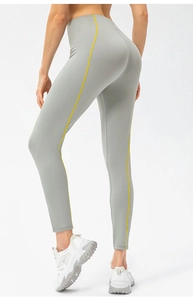 Détail du legging de yoga gris taille haute avec bandes jaunes et effet sculptant fessier