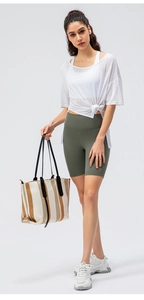 Detail view of women's sports set with white translucent tee and green cycling shorts