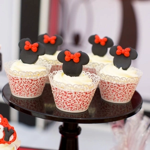 Lace hollow cupcake wrappers with Minnie-themed toppers in red, black, and white