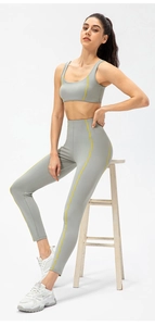 Détail d'un ensemble de yoga taille haute en maille grise avec coutures contrastées jaunes