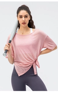 Detail of light pink breathable yoga top featuring a stylish side-knot hem design
