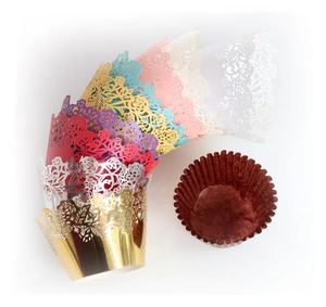 Macro detail of laser-cut rose pattern cupcake wrappers in metallic pearl colors