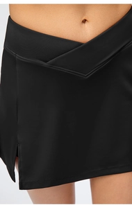 Close-up of black sports skort with high-waist crossover design and side slit detail