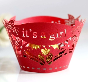Detailed laser-cut red cupcake wrapper featuring the it's a girl text and floral hollow pattern