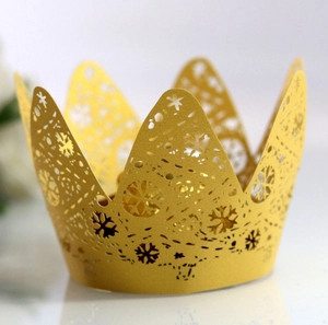 Macro view of laser-cut crown cake wrapper with snowflake patterns and golden finish