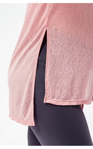 Detail view of pink yoga shirt featuring side split design and breathable textured fabric