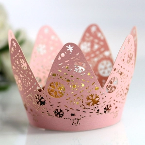 Detail of pink laser-cut crown cake wrapper with intricate snowflake pattern decoration