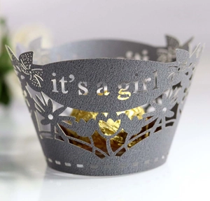 Detail showing laser-cut it's a girl text and floral patterns on grey cupcake wrapper