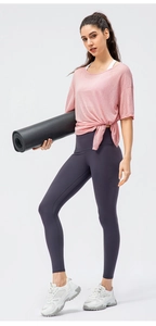 Detail of pink yoga top with side knot design and high waist purple sports leggings
