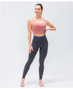 Gros plan sur brassière de sport rose et legging taille haute gris foncé sur un mannequin