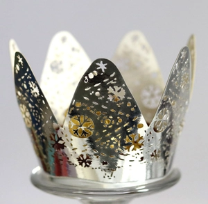 Macro shot of silver metal crown candle holder with laser-cut snowflake patterns