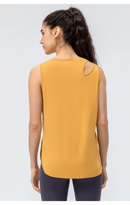 Detail eines ingwergelben Yoga-Tops mit geometrischen Schulter-Cut-outs und Bogensaum