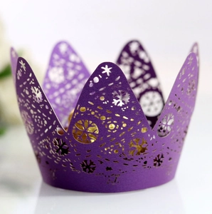 Macro detail of laser-cut purple snowflake crown cupcake wrapper for festive party