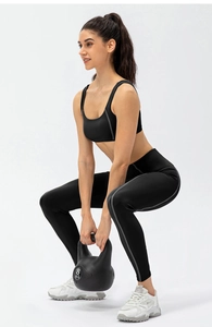 Détail de legging de yoga taille haute avec bandes réfléchissantes en posture de squat