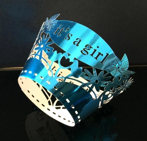 Close-up of laser-cut It's a Girl cupcake wrappers in metallic blue for baby showers
