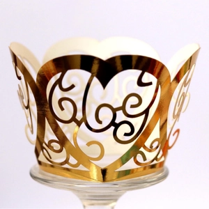 Golden laser-cut cupcake wrapper with heart filigree patterns for weddings