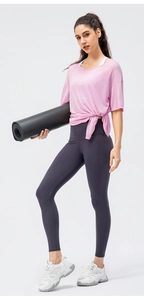 Detail of light pink yoga t-shirt with side knot design and high waist grey leggings