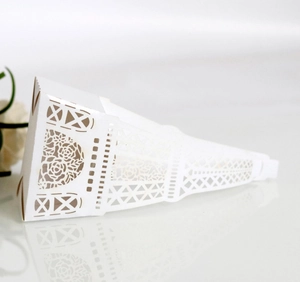 Macro detail of laser-cut rose floral hollow patterns on a white triangular favor box