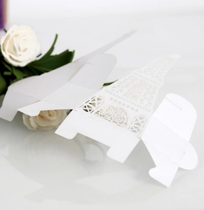 Macro detail of laser cut white paper wedding favor box with Eiffel Tower rose patterns