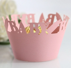 Pink laser-cut paper cupcake wrappers featuring Baby bottle hollow lettering for parties