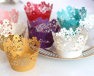 Macro shot of assorted pearl paper laser-cut cupcake wrappers in floral patterns