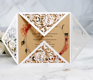 Detailed laser-cut floral wedding invitation with rose print on kraft paper insert