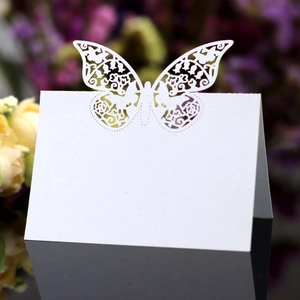 Elegant white laser-cut wedding place card featuring a delicate butterfly design detail