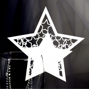 Laser-cut white star place card for wine glasses featuring intricate hollow star patterns