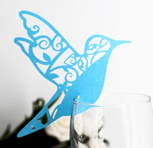 Blue laser-cut hummingbird paper card for wine glass rim decoration at weddings