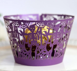 Detail of laser-cut purple Halloween cupcake wrapper with skull and spider web motifs