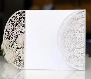 Elegant white laser-cut floral wedding invitation card with intricate pearl paper details